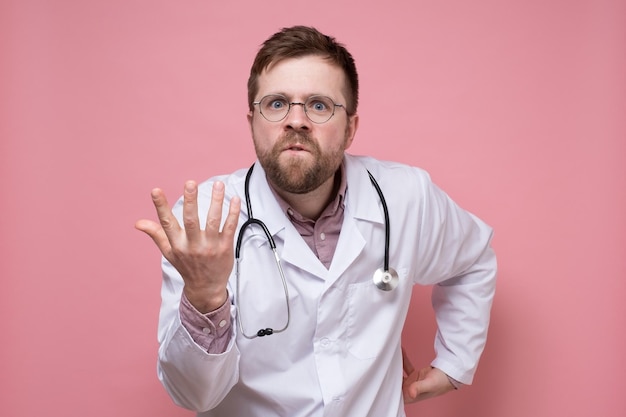 Lekarz ze stetoskopem na szyi oskarża kogoś i jest zły, że robi pytający gest