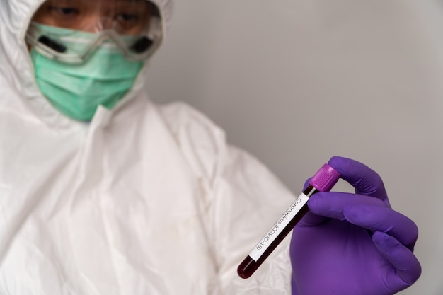 Lekarze w kombinezonach ochronnych i maskach mają pozytywny wynik testu krwi na nowy, szybko wybuchający koronawirus.