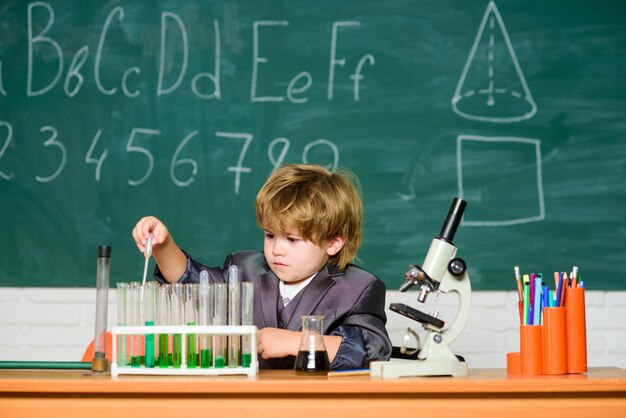 Lekcja chemii dla dzieci. Edukacja szkolna. Chłopiec używa mikroskopu i probówek w szkolnej klasie. Genialne maluch dziecko. Analiza chemiczna. Koncepcja nauki. Utalentowane dziecko i cudowne dziecko.