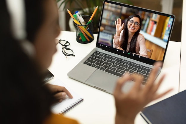 Lekcja online Nierozpoznawalna kobieta prowadząca rozmowę wideo na laptopie z korepetytorką