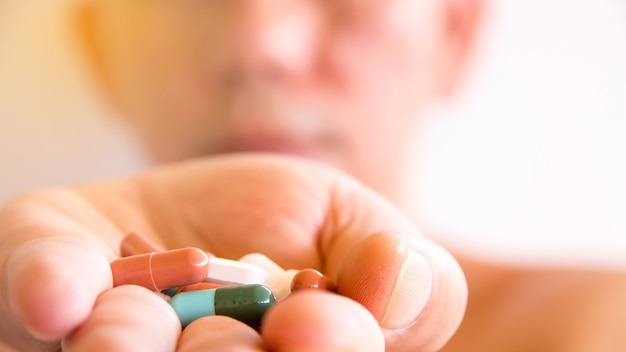 Zdjęcie leki w ręku, kolorowe doustnych leków na białym tle