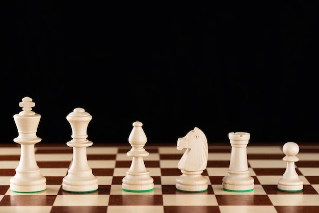 Lekkie drewniane szachy stojące w rzędzie na szachownicy