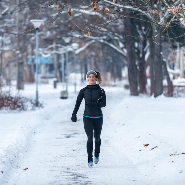 Lekkoatletka biegająca po parku w zimowy dzień w parku
