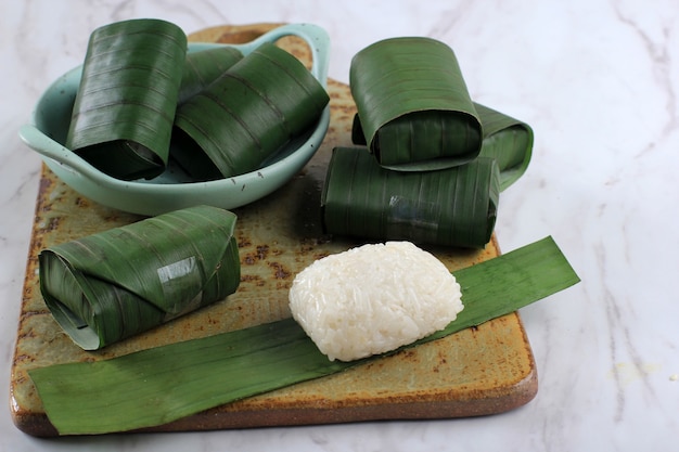 Lemper Ayam Podawany Z Herbatą. Lemper To Indonezyjska Przekąska Z Kleistego Ryżu Wypełniona Sezonowanym, Szatkowanym Kurczakiem Zawinięta W Liść Bananowca, Podawana Na Herbatę. Wybrany Fokus