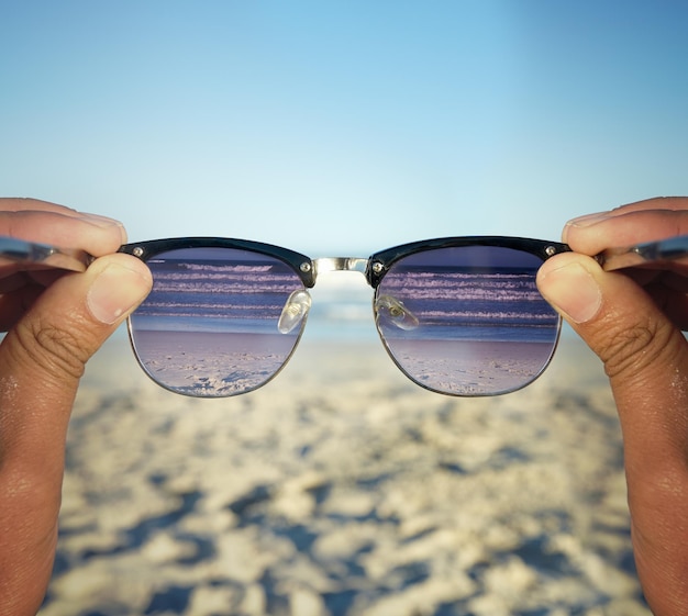 Lepsze życie na plaży Zdjęcie POV osoby na plaży patrzącej na fale przez okulary przeciwsłoneczne