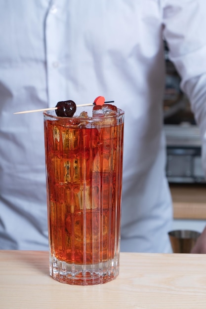 Letni chłodzący koktajl alkoholowy na stole barowym na tle barmana