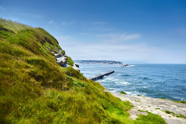Zdjęcie letni krajobraz z groblą oceaniczną i zielonym wzgórzem