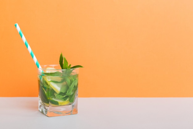 Letni orzeźwiający koktajl Mojito z lodem i miętą Koktajl mojito z limonkową cytryną i miętą w wysokiej szklance z patyczkiem