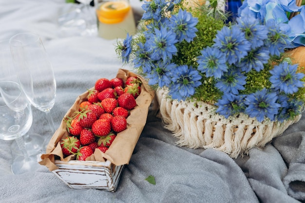 Letni piknik w słoneczny dzień z chlebem bukiet owoców hortensja kwiaty kieliszki wina