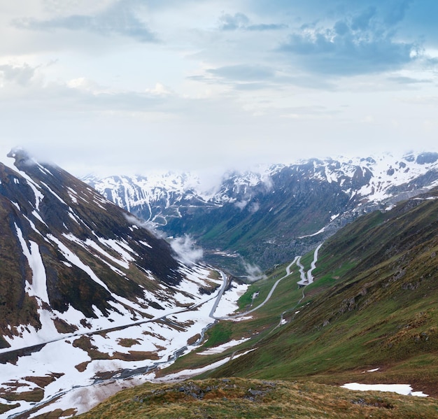 Letni pochmurny krajobraz górski z drogą Furka Pass Szwajcaria