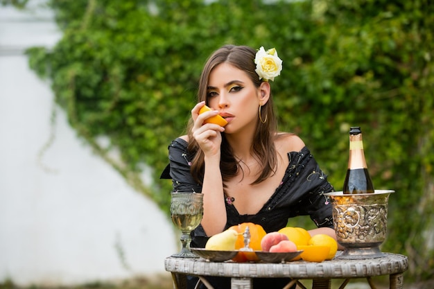 Letni portret pięknej mody kobieta je pomarańczowe letnie owoce na świeżym powietrzu Piękna kobieta ciesząc się wiosną Ładna dziewczyna relaks w ogrodzie Seksowna kobieta wyciskając sok ze świeżej pomarańczy