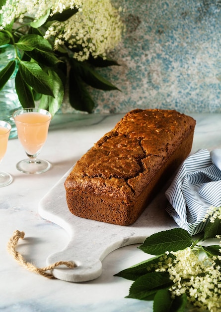 Letni słodki bochenek na stole z kwiatami i drinkiem w szklankach deser na brunch lub poranne śniadanie