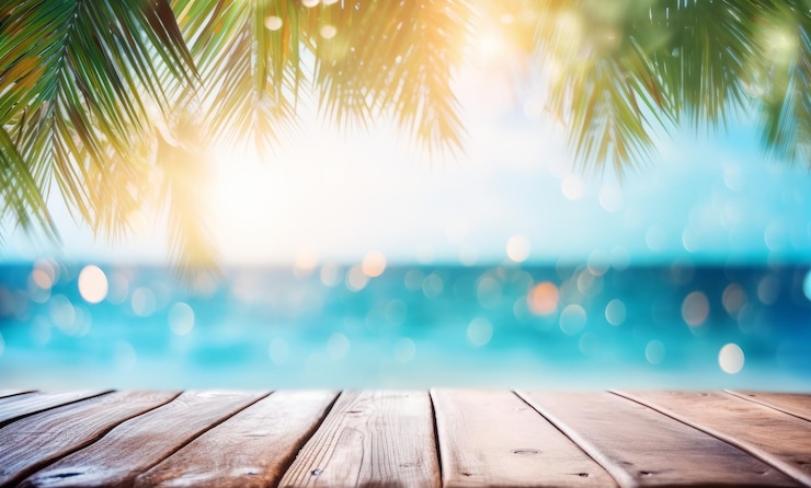 Zdjęcie letni stół plażowy z niewyraźnymi liśćmi palmowymi i niewyraźnymi światłami bokeh na oceanie w tle drewniana deska w abstrakcyjnym krajobrazie
