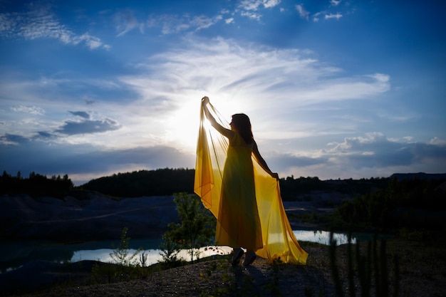 Letni styl życia oszałamiająca szczęśliwa kobieta biegająca w przyrodzie. W długiej żółtej sukience. Romantyczny nastrój. Ciesząc się słońcem. Słoneczny dzień. Selektywne skupienie