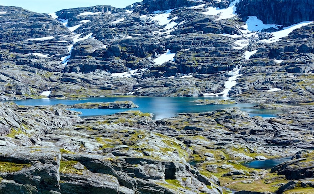 Letni widok na skaliste góry z małym jeziorem (Norwegia). Droga do Trolltungi.