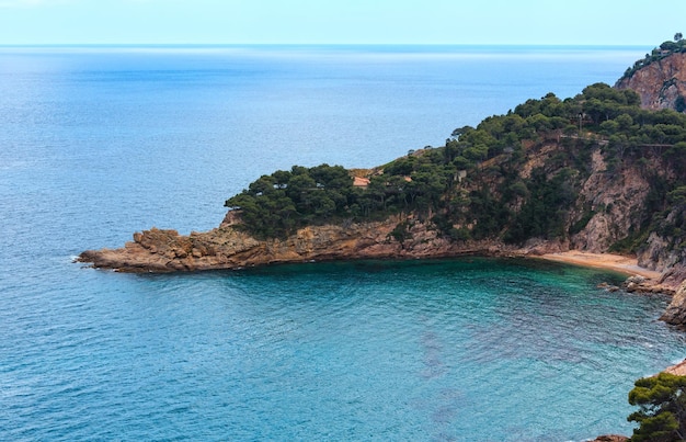 Letni widok na skaliste wybrzeże z małą piaszczystą plażą. Costa Brava, Katalonia, Hiszpania.