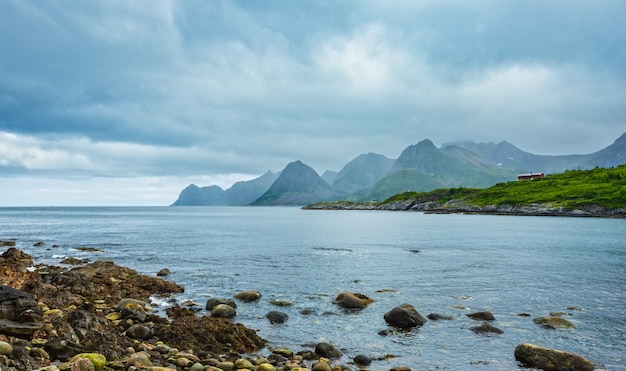 Letni widok na wybrzeże fiordu Senja w pobliżu miasta wysepka Husoy, Norwegia. Pochmurna pochmurna pogoda.