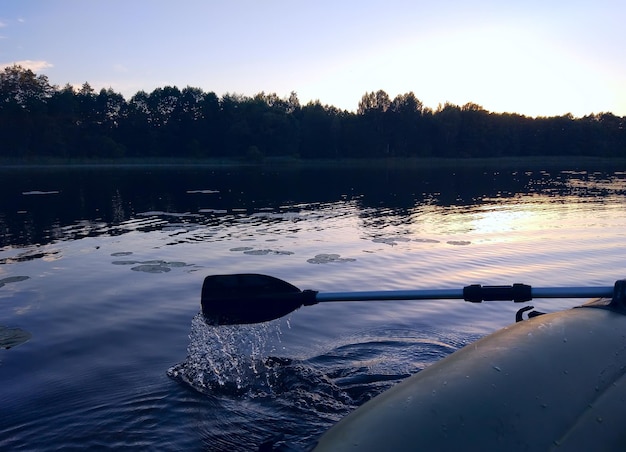 Letni wieczór krajobraz z taflą jeziora i fragmentem wiosła pontonu. Łotwa, Europa Wschodnia.
