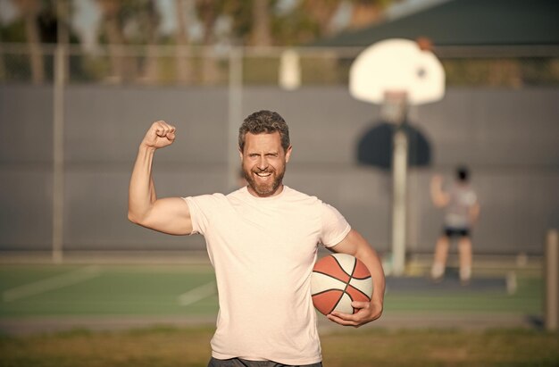 Letnia aktywność szczęśliwy muskularny mężczyzna z trenerem koszykówki lub koszykarzem