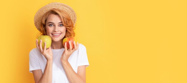 Letnia dziewczyna trzyma jabłko Piękna kobieta odizolowana twarz portret transparent z makietą kopii przestrzeni witamina i dieta kobieta w słomkowym kapeluszu jedzenie zdrowej żywności zdrowie młodzieży