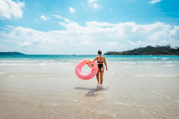 Letnia podróż kobieta trzymająca wewnętrzną rurkę chodząca po środku morza