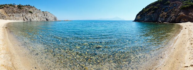 Letnia sceneria morza z akwamarynową przezroczystą wodą i piaszczystą plażą. Widok z brzegu (Goa Beach Bar, Sithonia, Halkidiki, Grecja).