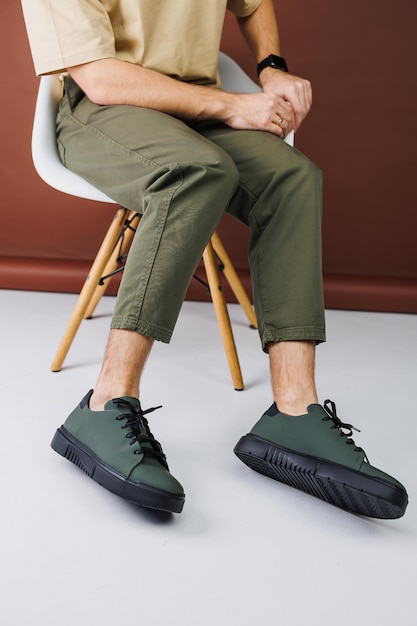 Letnie buty Zbliżenie męskich nóg w zielonych spodniach i zielonych trampkach dorywczo Letnie skórzane buty męskie