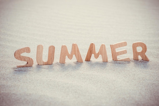Zdjęcie letnie drewniane litery na piasku