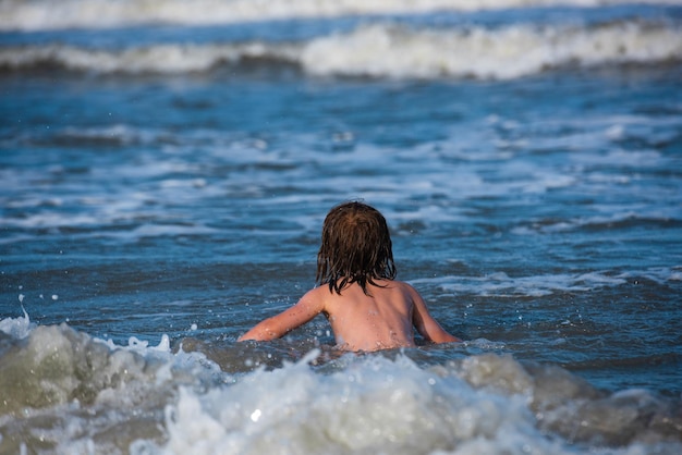 Letnie wakacje dla dzieci i koncepcja zdrowego stylu życia słodkie dziecko bawiące się na piaszczystej plaży latem