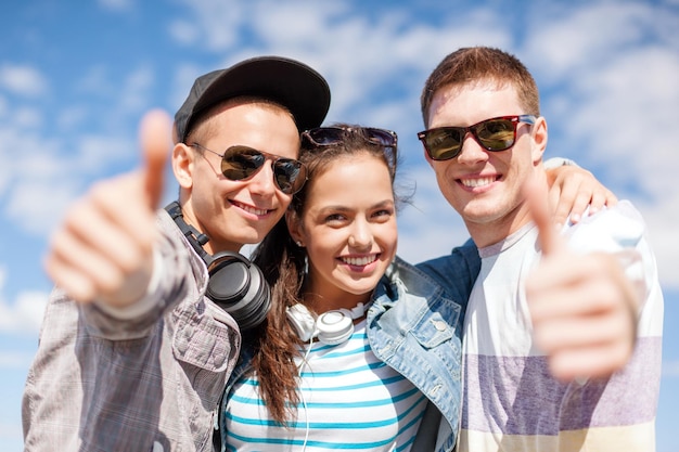 letnie wakacje i nastoletnia koncepcja - grupa uśmiechniętych nastolatków pokazujących kciuki w górę