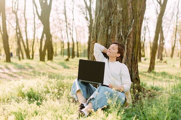 Letnie wakacje park trawa kobieta laptop komunikacja