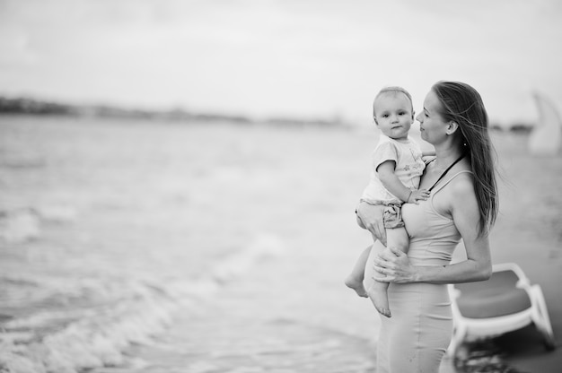 Letnie wakacje. Rodzice i ludzie na świeżym powietrzu z dziećmi. Wesołych rodzinnych wakacji. Matka w ciąży z córeczką na piaszczystej plaży.