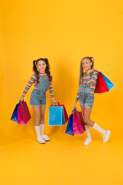 Letnie zakupy Kupujący koncepcja konsumenta Zakup wakacyjny oszczędzający małe dzieci z ciężkimi torbami na zakupy duża wyprzedaż prezentów szczęśliwe zakupoholiczki dzieci pakiety opieki dla małych dziewczynek Zakupy w domu