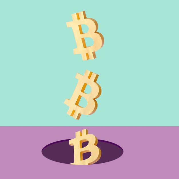 Lewitacja bitcoinów wpadająca w dziurę jako minimalna kreatywna koncepcja zysku i straty lub sukcesu i ryzyka na rynku kryptowalut z technologią blockchain