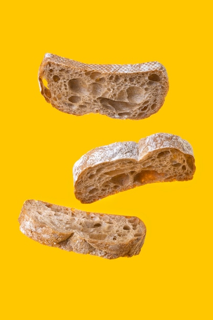 Lewitacja trzy kromki chleba na żółtym tle.