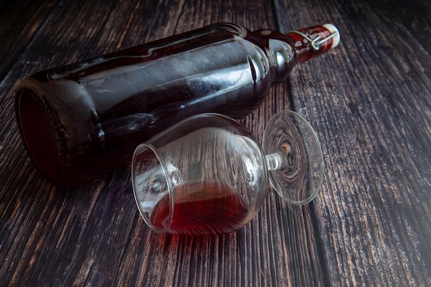 Leżące szklanki i butelka czerwonego wina na stole