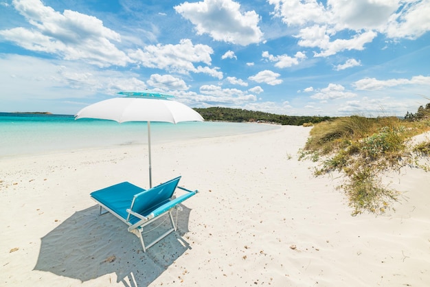 Leżak i parasol plażowy nad morzem pod zachmurzonym niebem