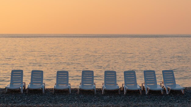 Leżak na plaży z pięknym tłem zachodu słońca Seascape