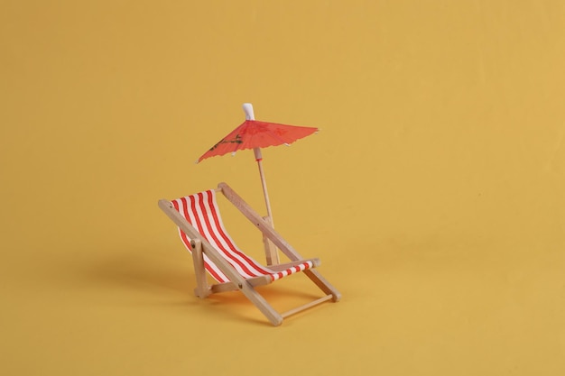 Leżak z parasolem na żółtym tle Odpoczynek na plaży