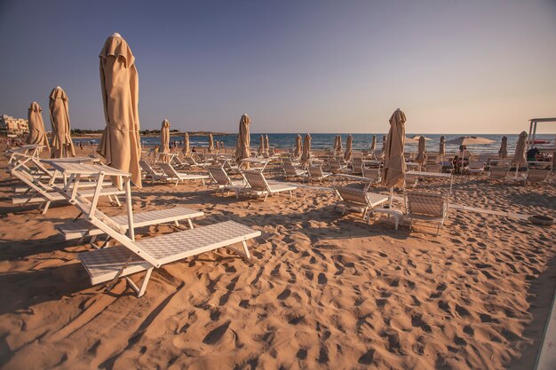 Leżaki i parasole na plaży Modica o zachodzie słońca