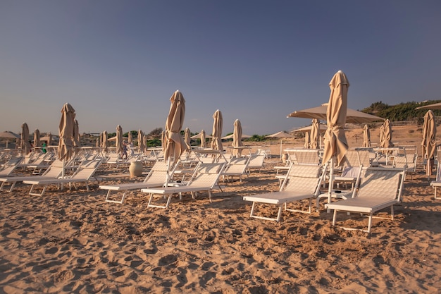 Leżaki i parasole na plaży Modica o zachodzie słońca