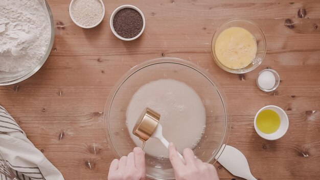 Leżał płasko. Krok po kroku. Mieszanie składników organicznych w szklanej misce, aby upiec chałkę.