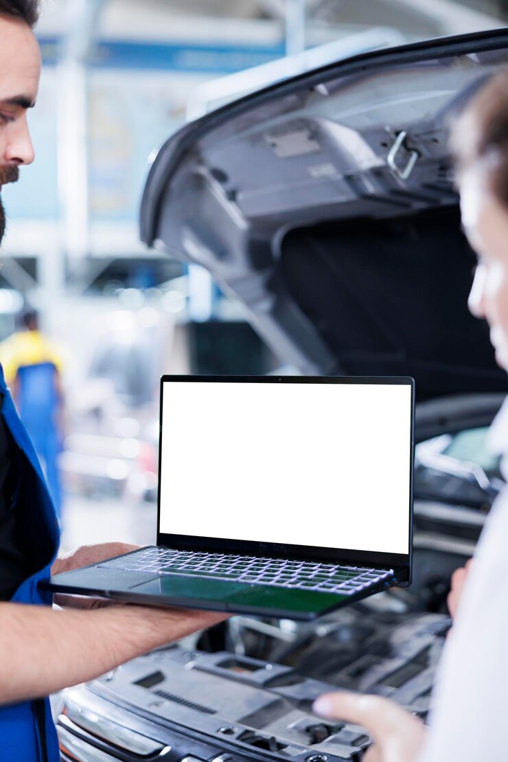 Licencjonowany mechanik w garażu używający laptopa do śledzenia listy kontrolnej podczas konserwacji samochodu Skrupulatny ekspert w warsztacie samochodowym sprawdza pojazd za pomocą izolowanego urządzenia ekranowego