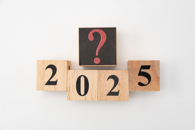Liczba 2025 i znak zapytania napisane na drewnianych blokach odizolowanych na białym tle