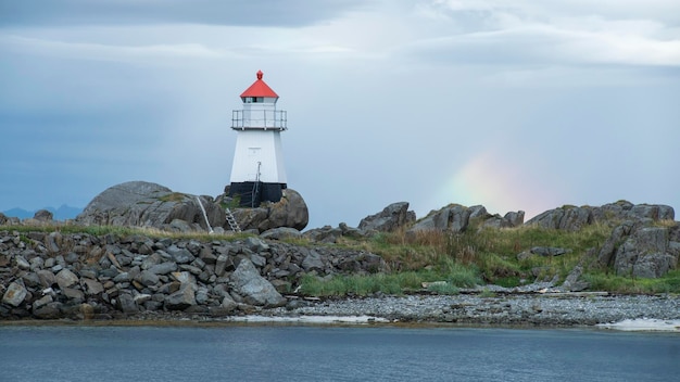 Zdjęcie lighthouse beacon na wybrzeżu w norwegii z rainbow