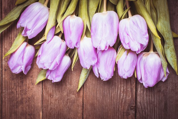 Liliowe tulipany na sfatygowanym białym drewnianym stole