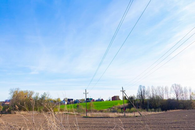 Linia energetyczna nad polem i na tle błękitnego nieba