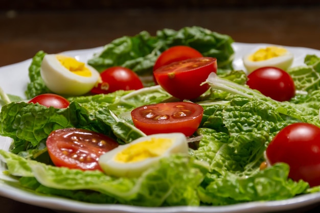 Liście sałaty pomidory czereśniowe i jajka przygotowane składniki na sałatkę Cezara