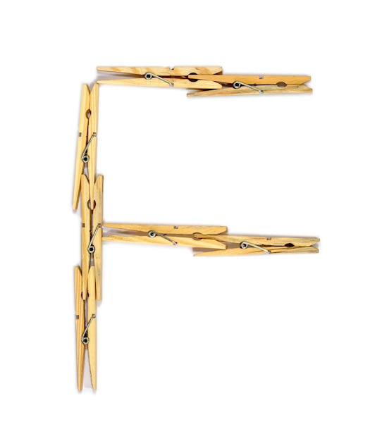 Litera F wykonana z drewnianych spinaczy do bielizny na białym tle