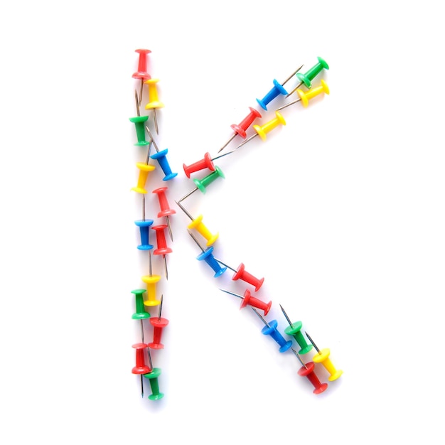 Litera K alfabetu angielskiego z kolorowych przycisków biurowych papeterii, izolować na białym tle
